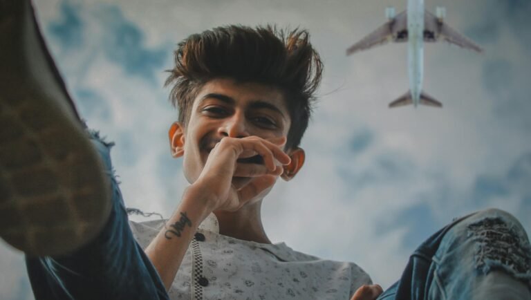 Teenager enjoying leisure time outdoors with airplane flying overhead, captured in a lively moment.